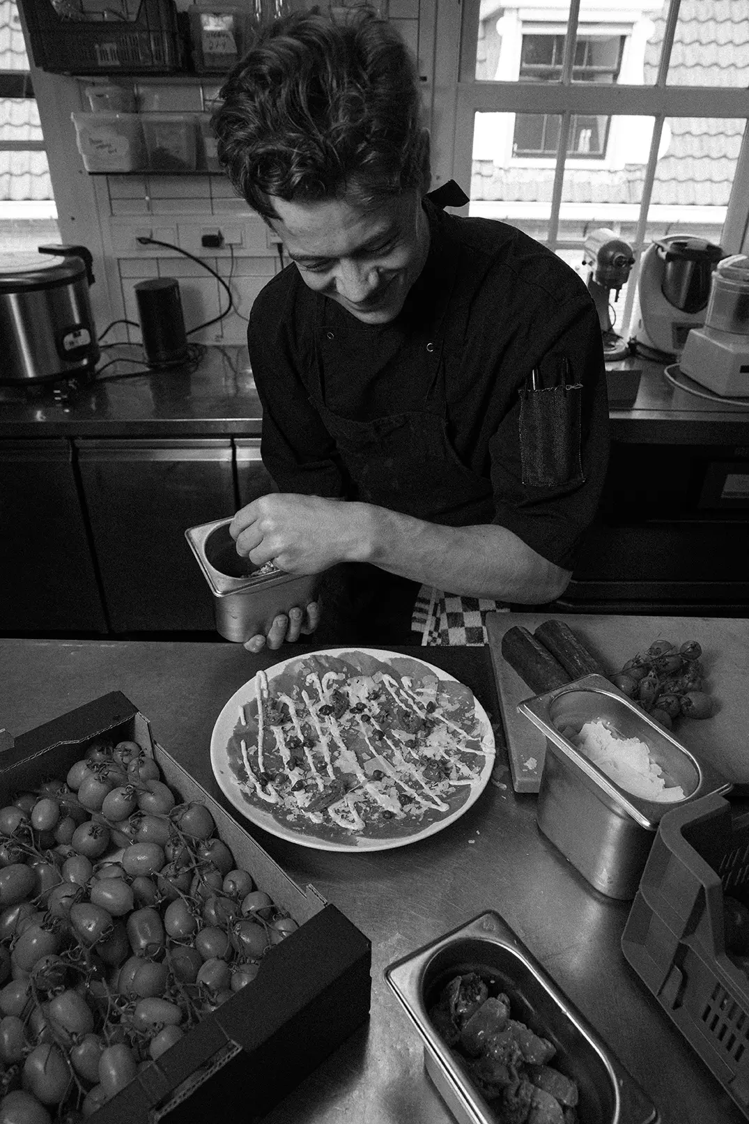 Kok maakt een gerecht af in de keuken
